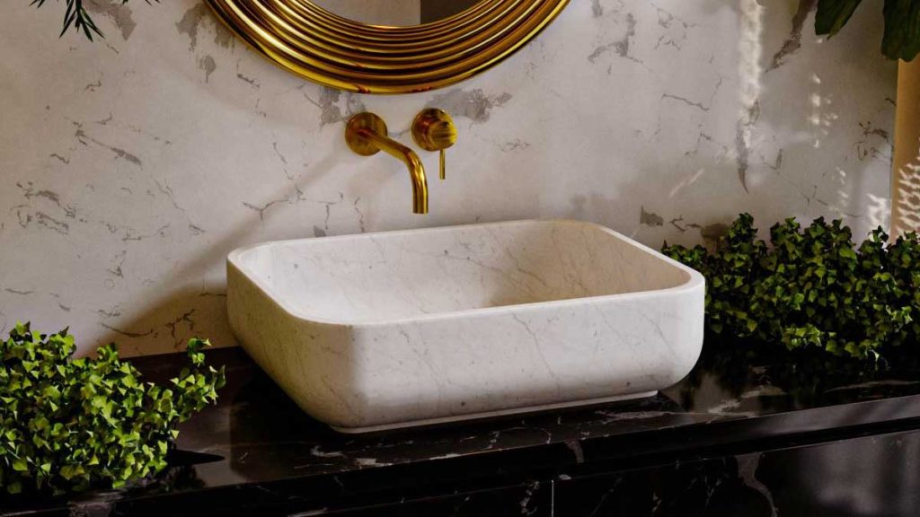prostokątna umywalka z kamienia naturalnego, biała umywalka i złote baterie umywalkowe